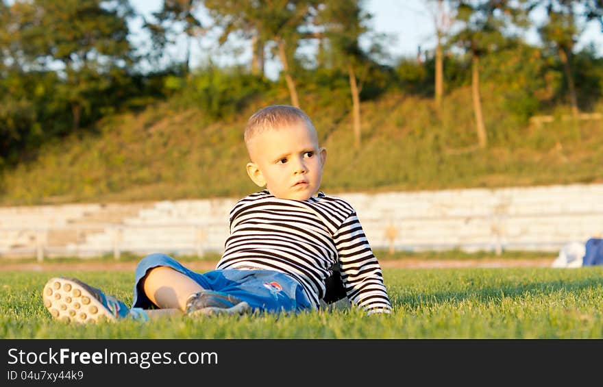 Little boy lying on green grass