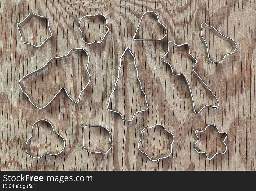 Metal molds for Christmas cookies on a wooden texture. Metal molds for Christmas cookies on a wooden texture.