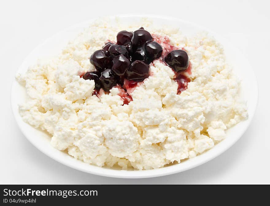 Fresh cottage cheese in the bowl with cherry jam  on a white. Fresh cottage cheese in the bowl with cherry jam  on a white