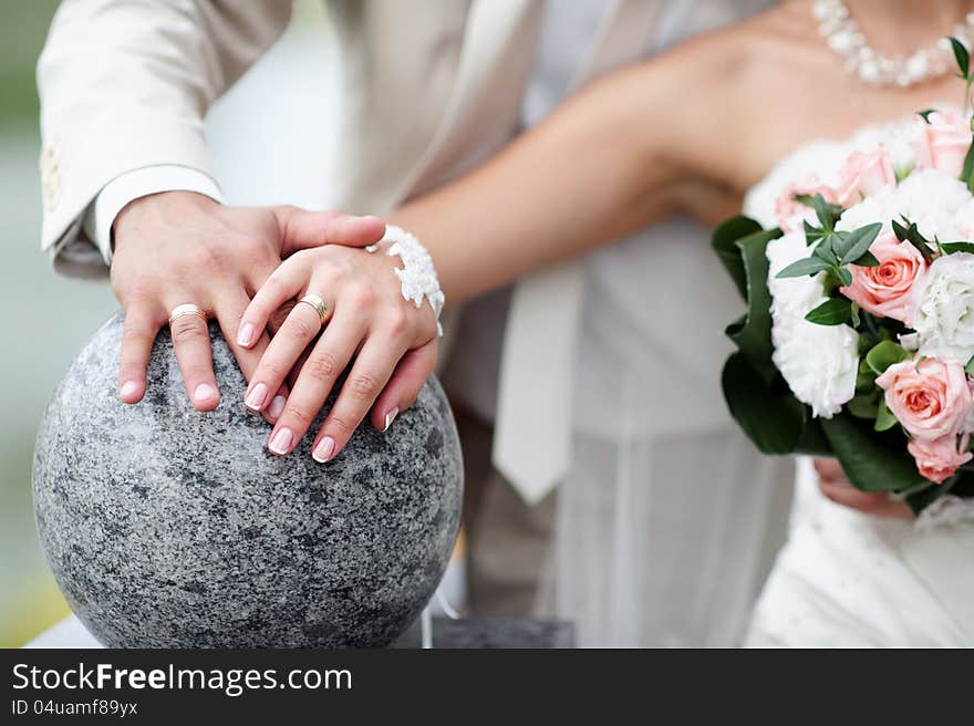 Bride and groom with flowers and wedding rings close-up