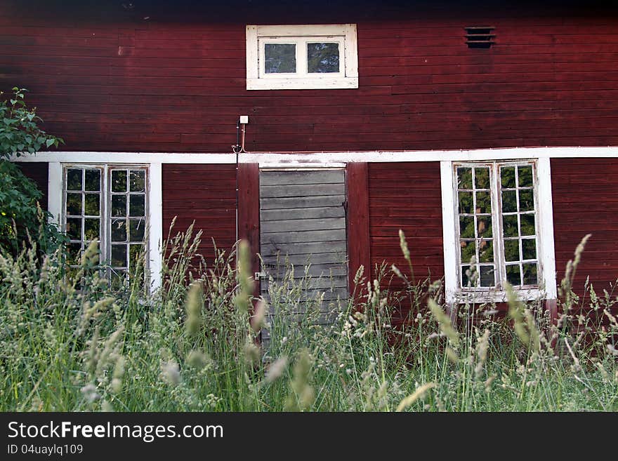 Old abandoned building in red hardwood and white windows. Old abandoned building in red hardwood and white windows