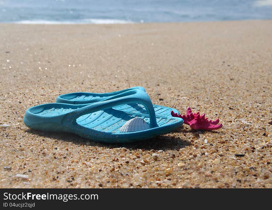 Flip-flops and pink starfish on the beach