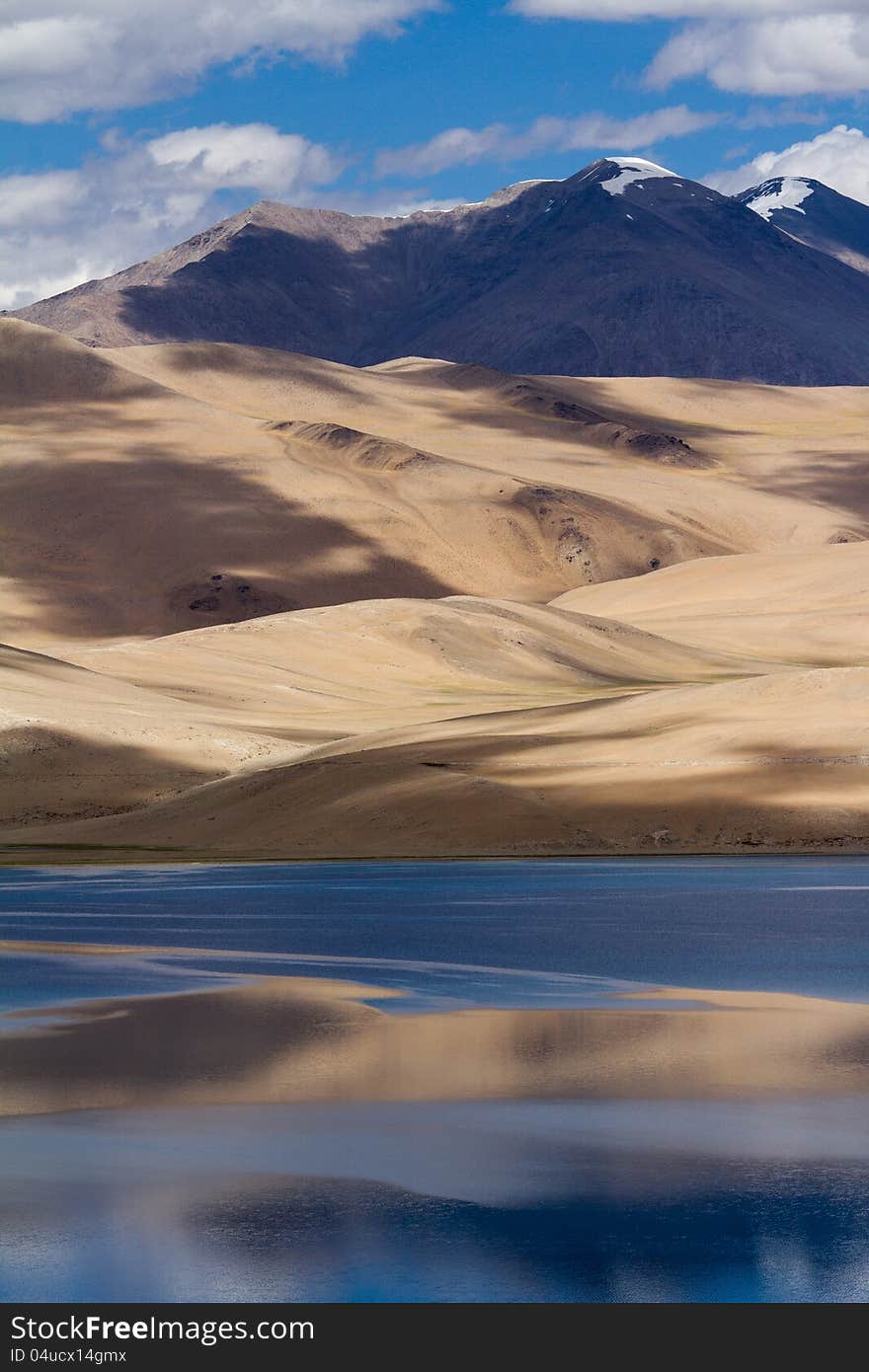 Tsomoriri mountain lake panorama with mountains and blue sky reflections in the lake (north India)