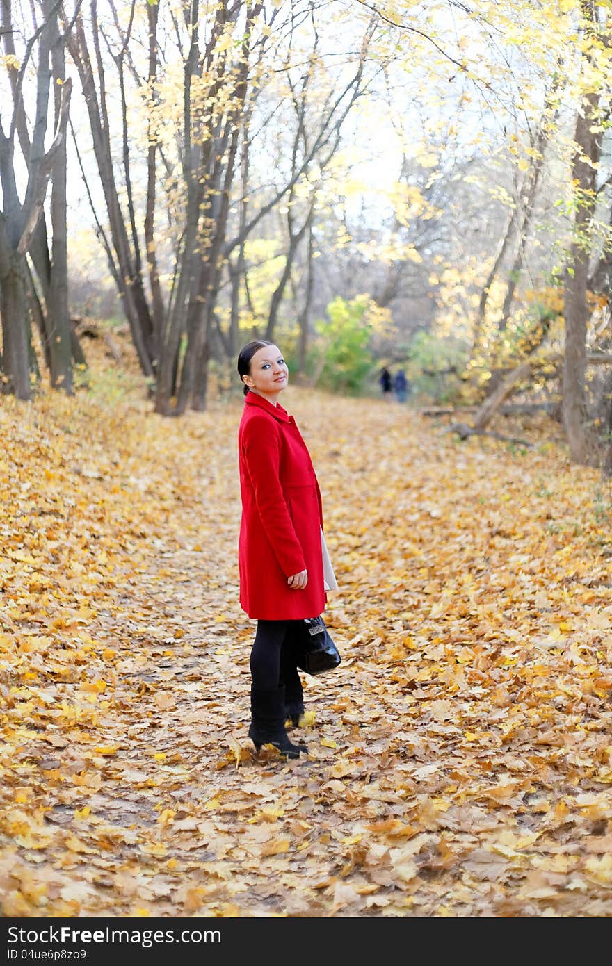 Pretty girl in the autumn forest by day