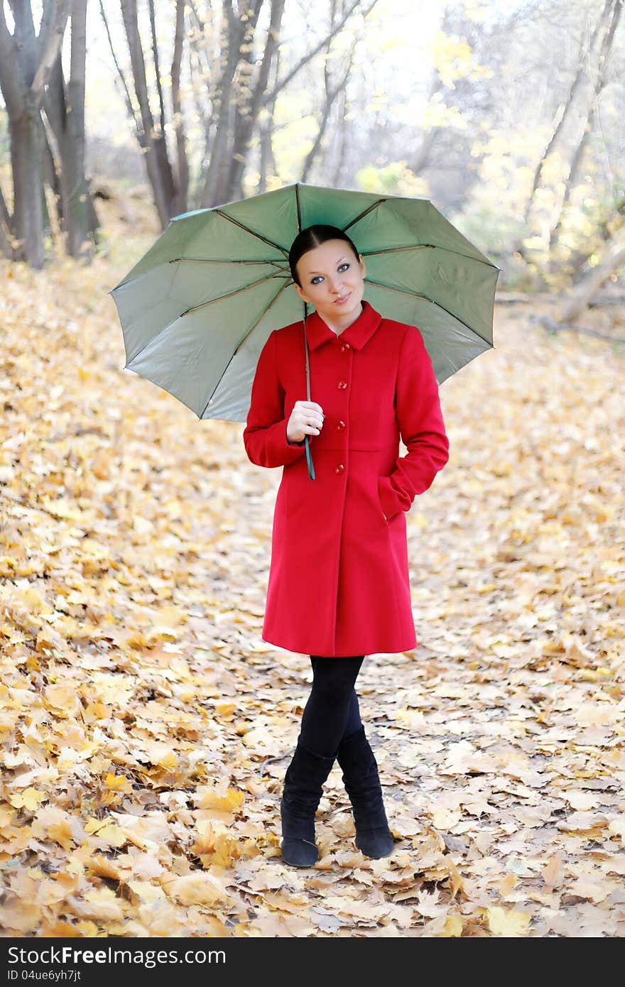 Cute girl in the autumn forest with umbrella