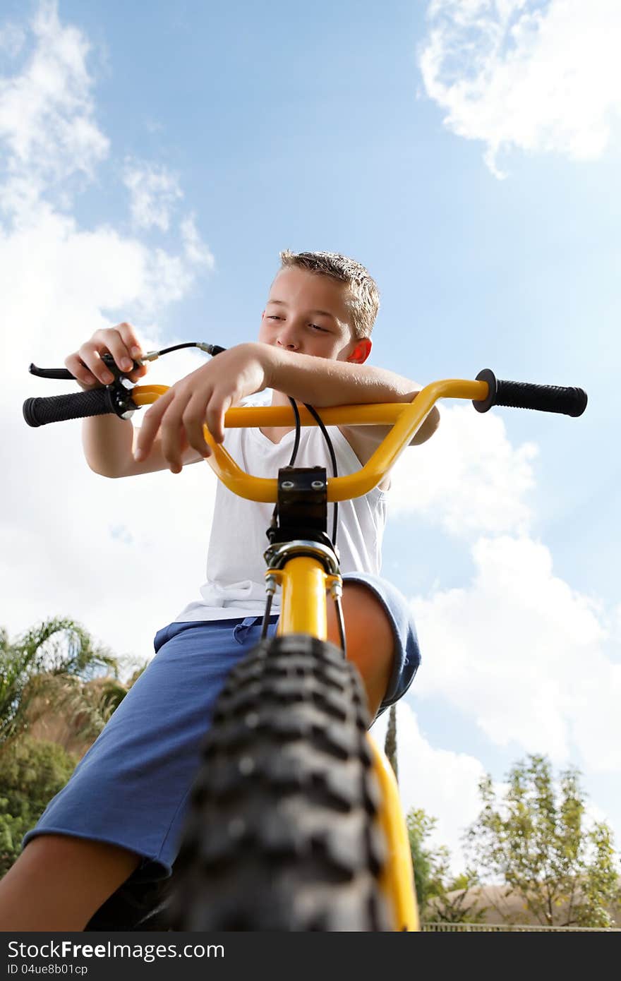 Pretty boy on a bicycle outside in the afternoon