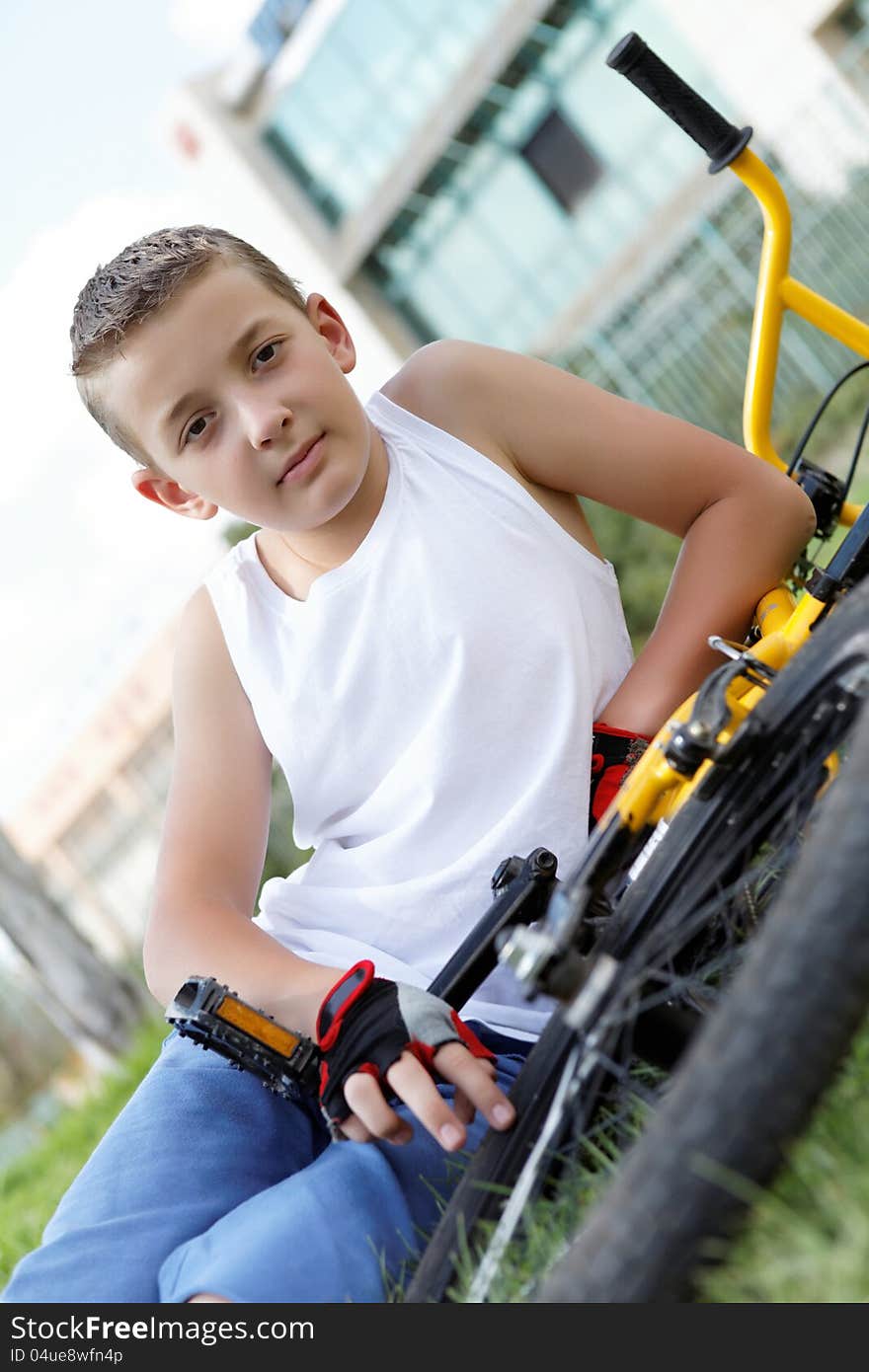 Pretty boy with his bicycle outside