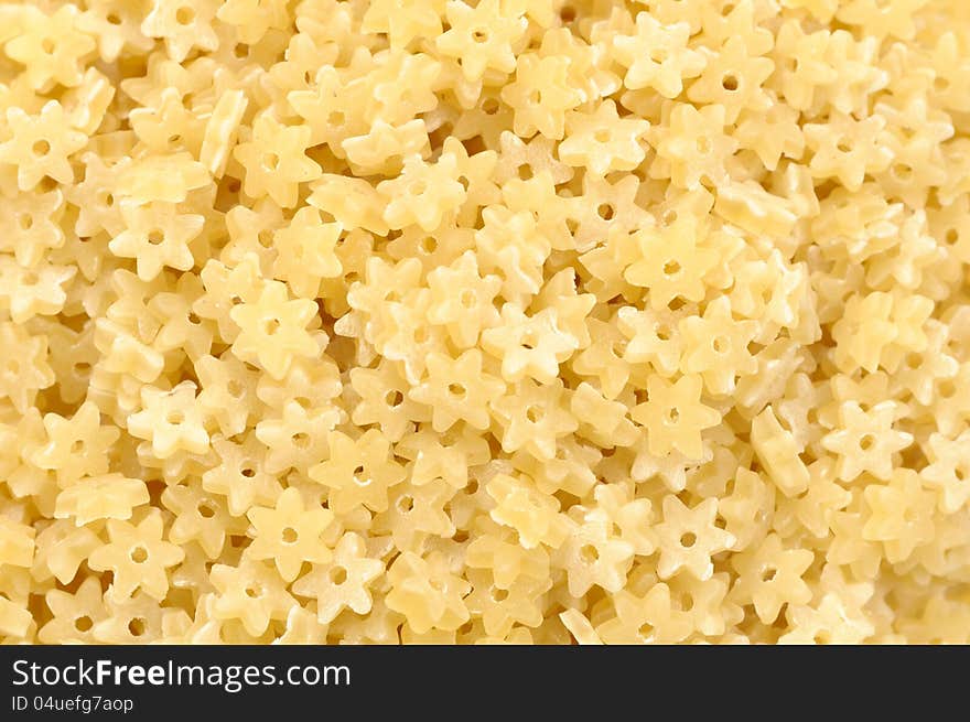 A close-up of star-shaped stelle pasta as a background. A close-up of star-shaped stelle pasta as a background