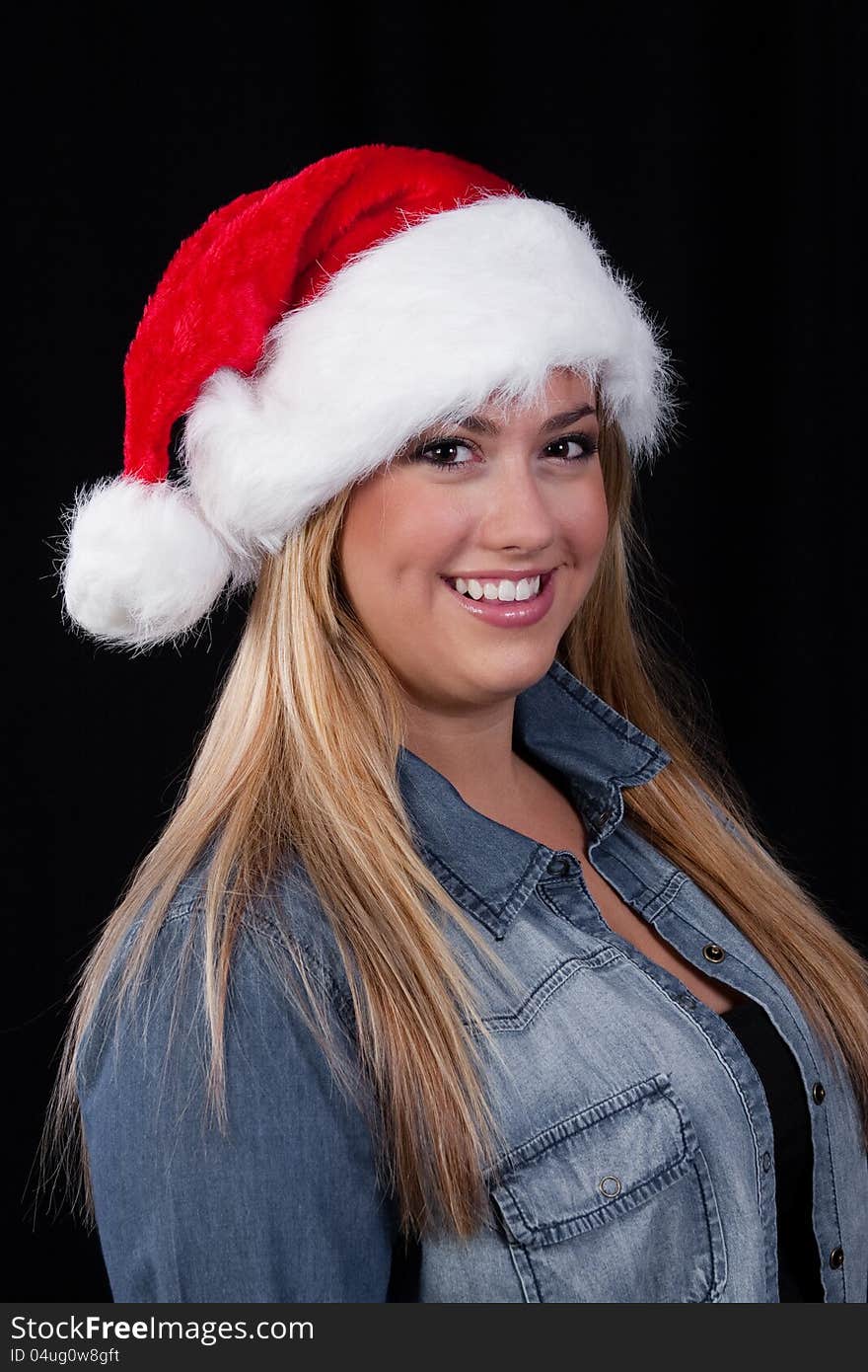 A portrait of a smiling, blond, Christmas Santa girl with red hat