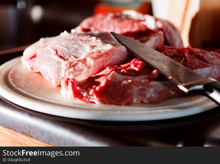 Several pieces of fresh pork on the cutting board with knife,shallow focus