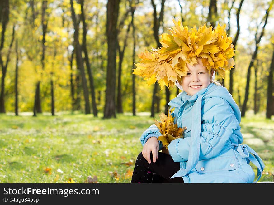 Little girl wearing a crown of autumn leaves