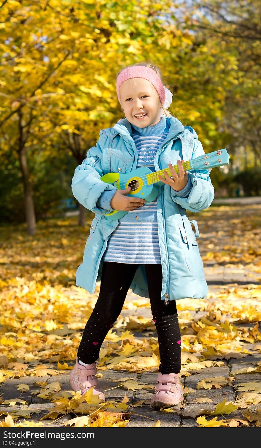 Cute little girl playing a toy guitar