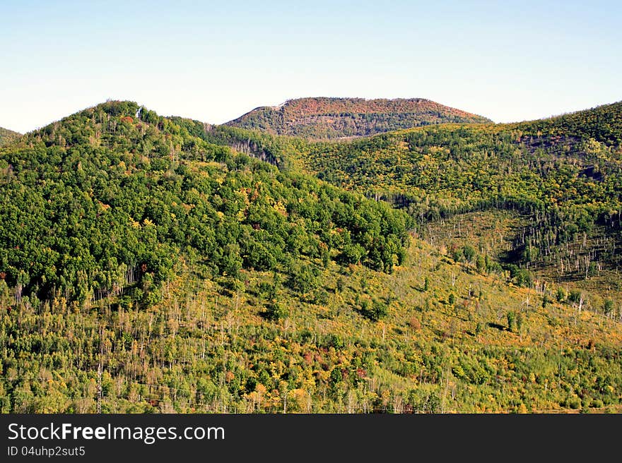 Hillsides are covered by wood. Hillsides are covered by wood