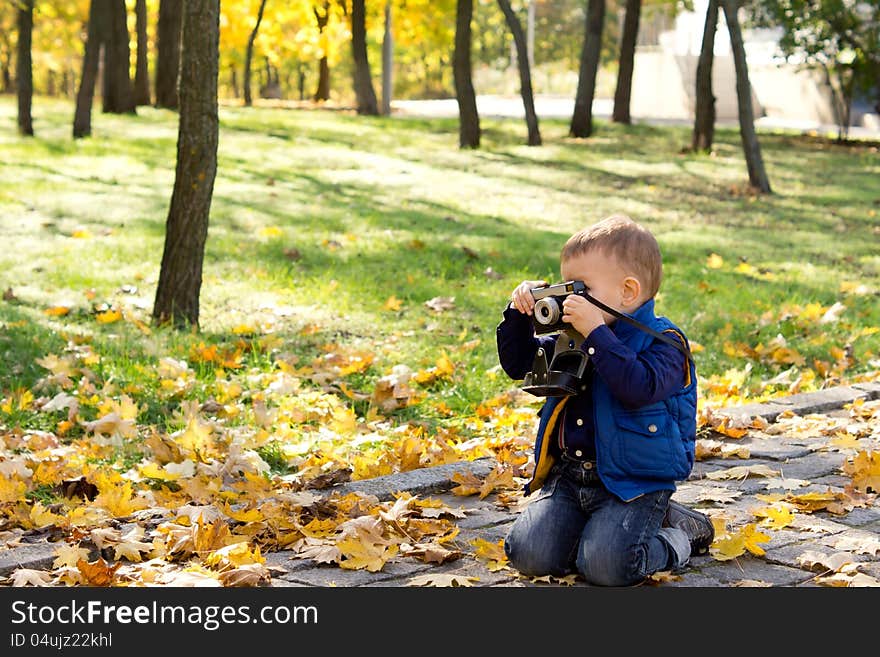 Small boy using a vintage slr camera