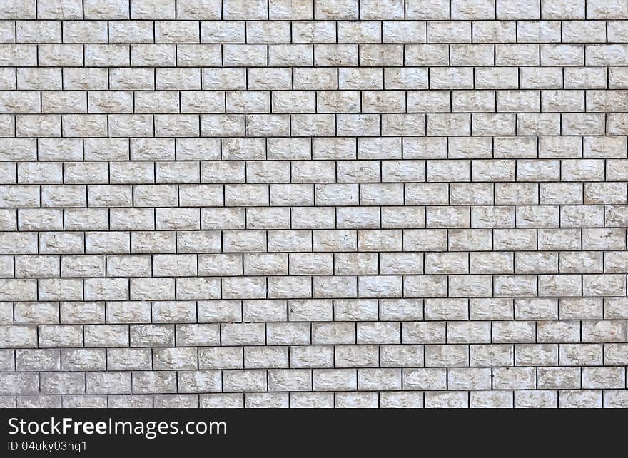 A wall made up of tiled rectangular blocks of stone. A wall made up of tiled rectangular blocks of stone