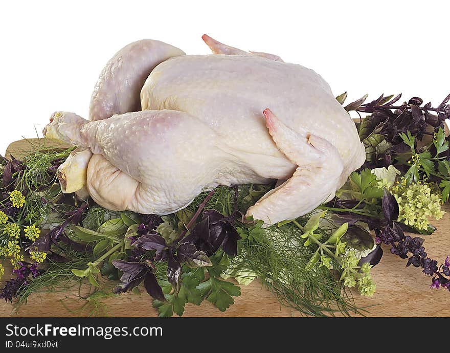 Raw chicken with herbs on a cutting board isolated on white