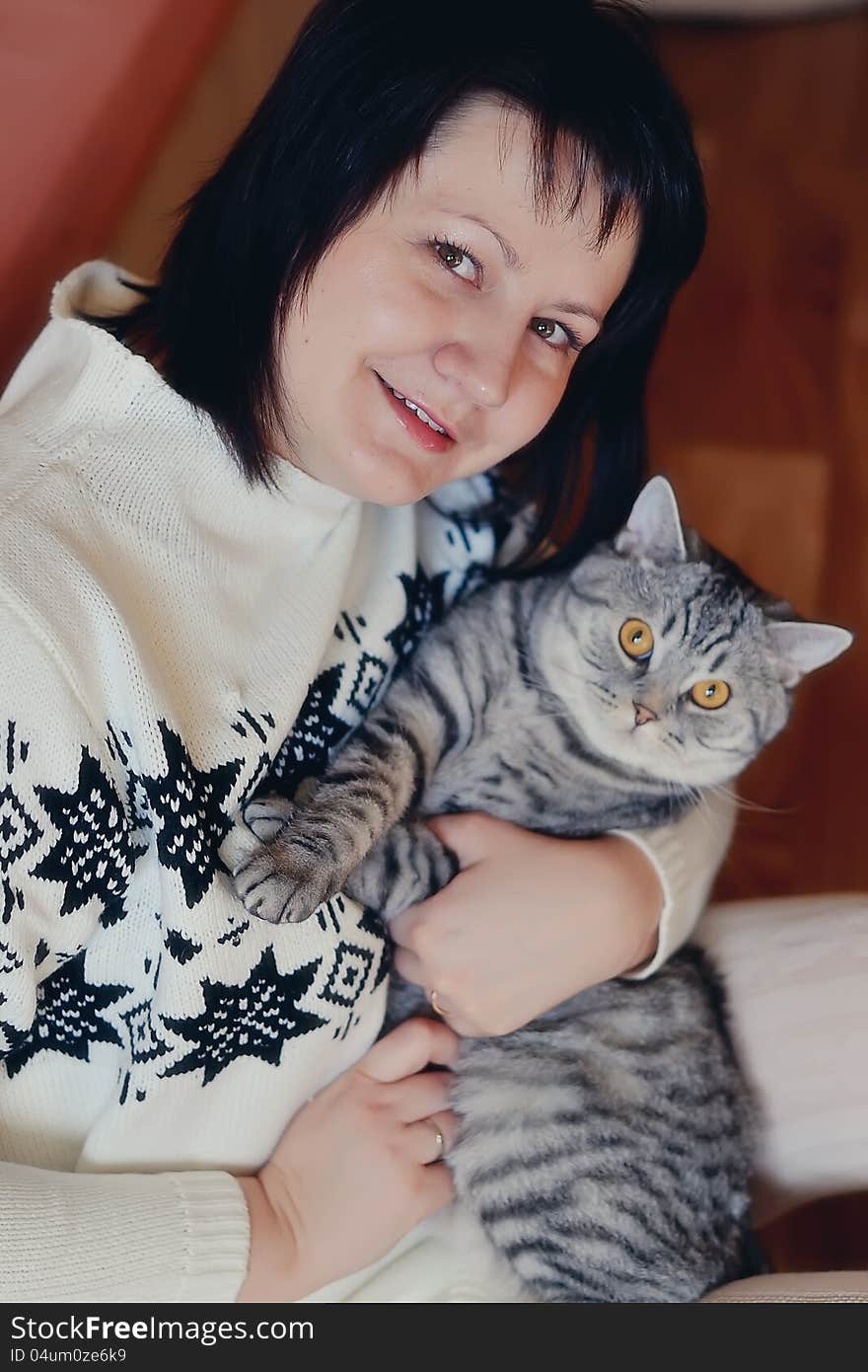 Home girl is sitting on the floor in a white suit with a cat. Home girl is sitting on the floor in a white suit with a cat