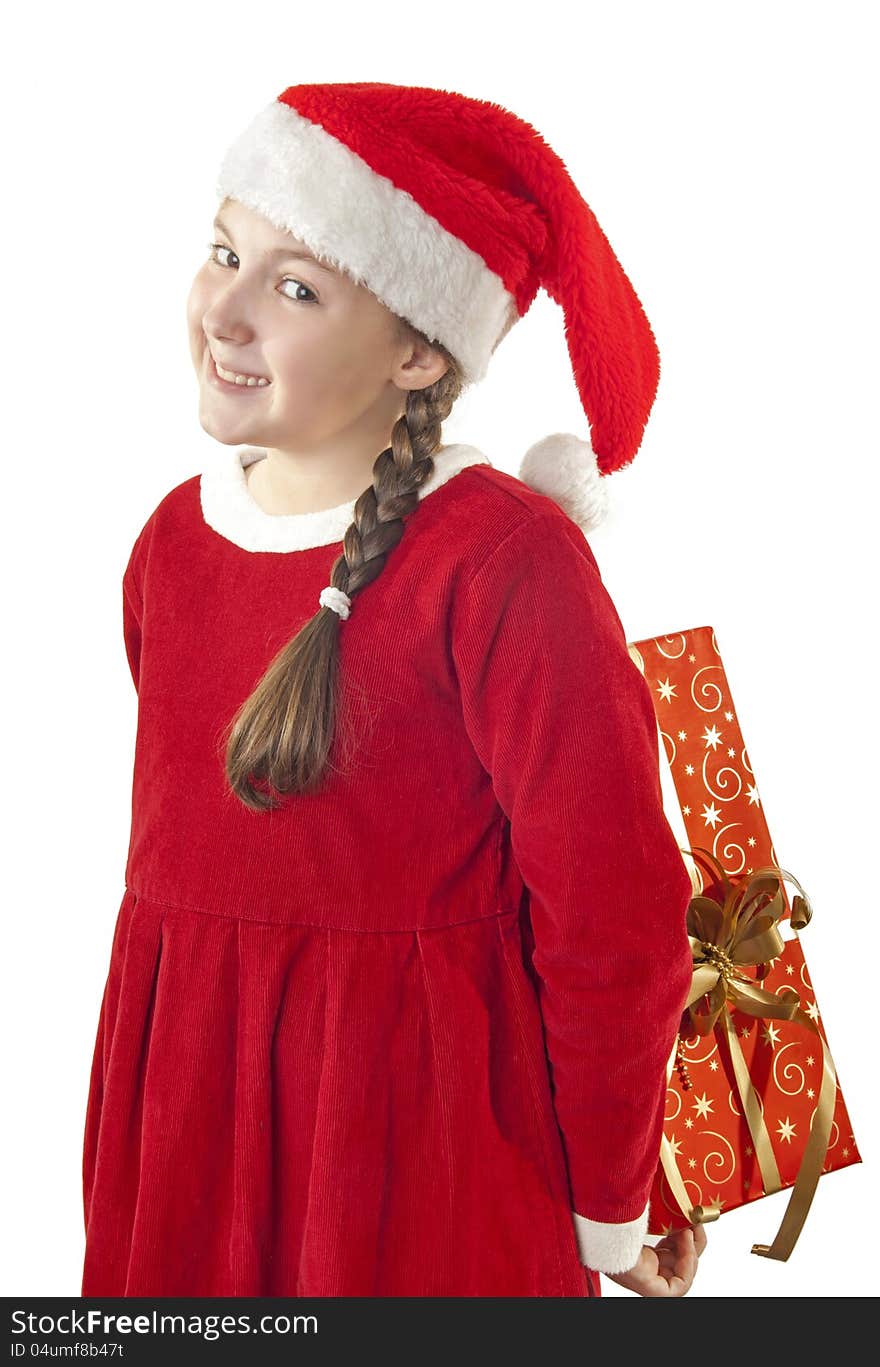 Beautiful girl dressed in Christmas clothes and red santa hat with present behind her back isolated on white background. Beautiful girl dressed in Christmas clothes and red santa hat with present behind her back isolated on white background