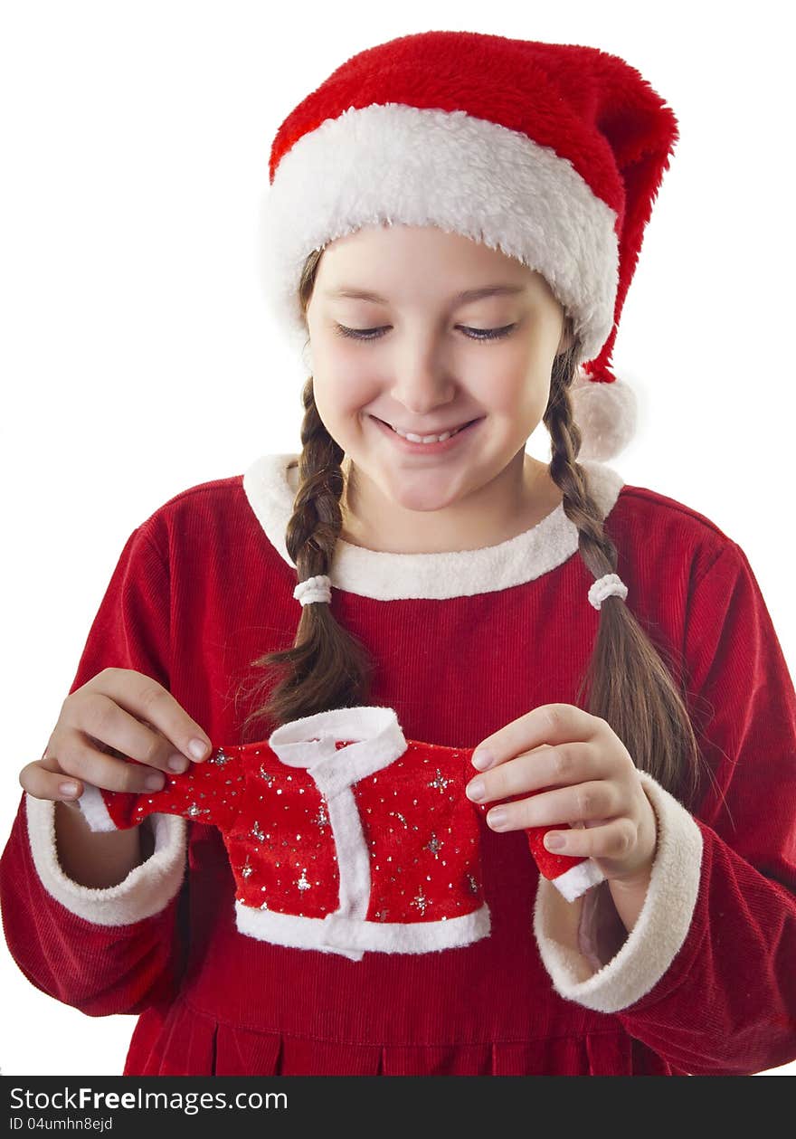 Beautiful girl dressed in Christmas clothes and red santa hat holding little santa clothes in her hands isolated on white background. Beautiful girl dressed in Christmas clothes and red santa hat holding little santa clothes in her hands isolated on white background