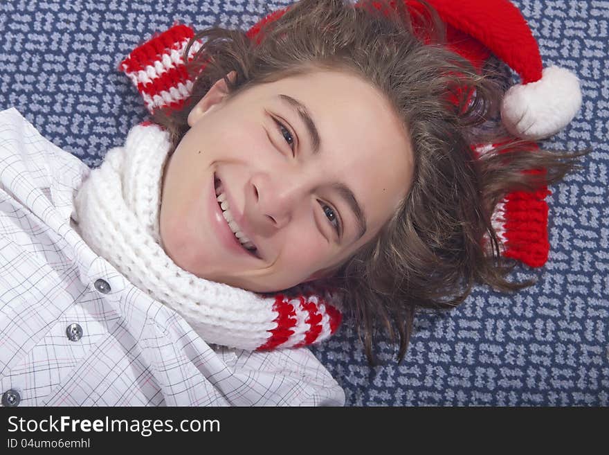 Handsome teenage boy lying on the floor with Christmas hat. Handsome teenage boy lying on the floor with Christmas hat