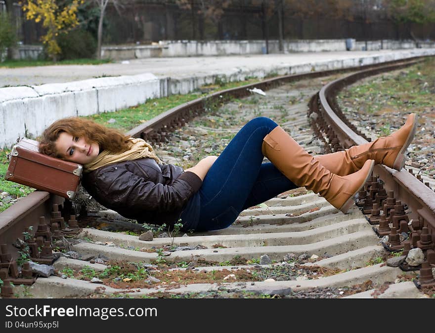 Girl with a suitcase lying on the tracks. Girl with a suitcase lying on the tracks