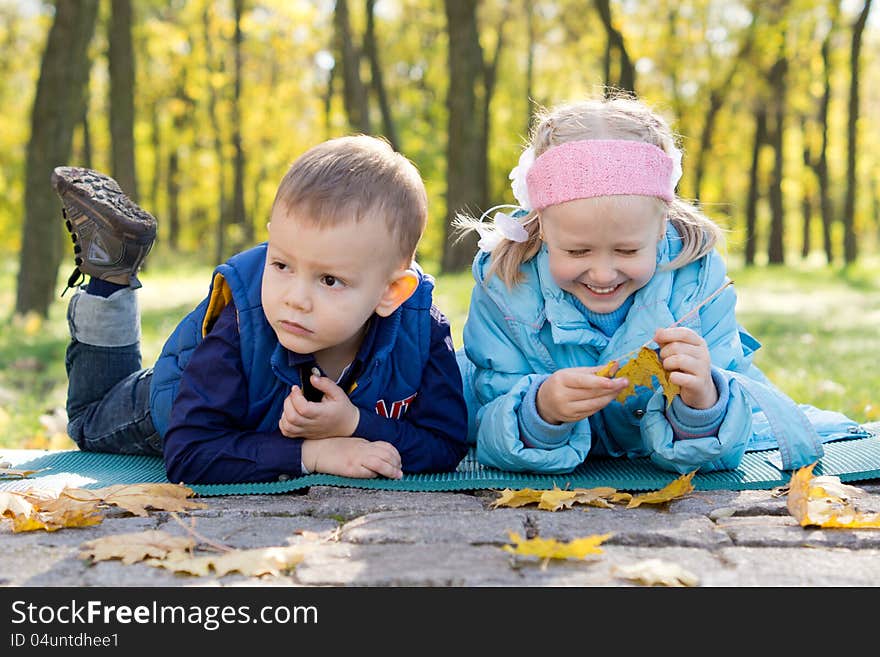 Small Children Relaxing in a Park in Autumn