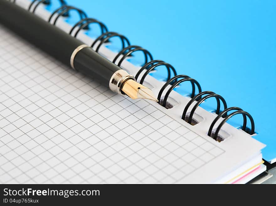 Closeup of blank open spiral notebook and fountain pen. Good background. Closeup of blank open spiral notebook and fountain pen. Good background