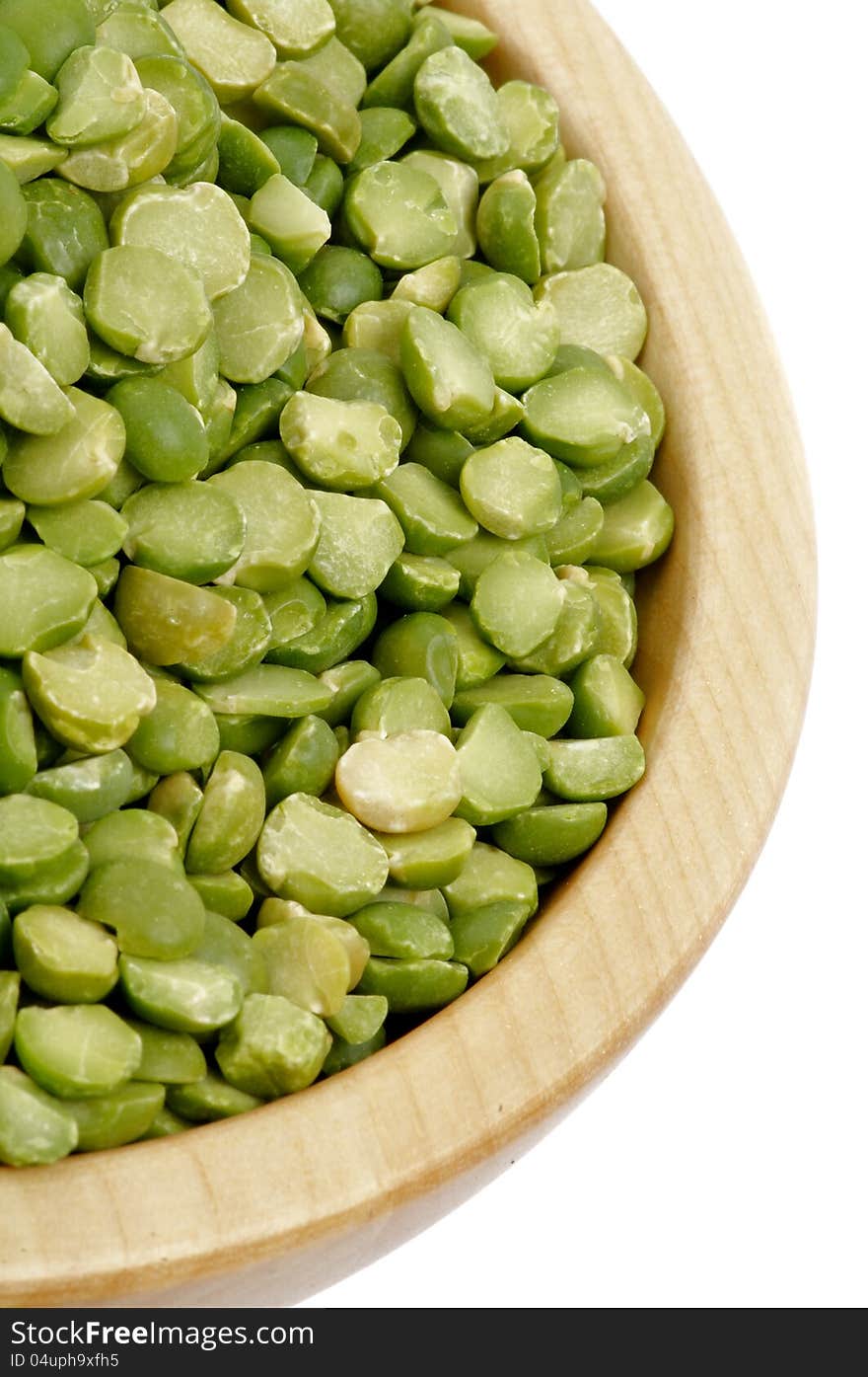 Green Split Peas in Wooden Bowl closeup on white background