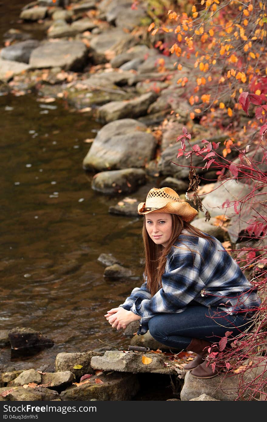 Pretty young girl at the riverside enjoying a beautiful day in autumn. Pretty young girl at the riverside enjoying a beautiful day in autumn.