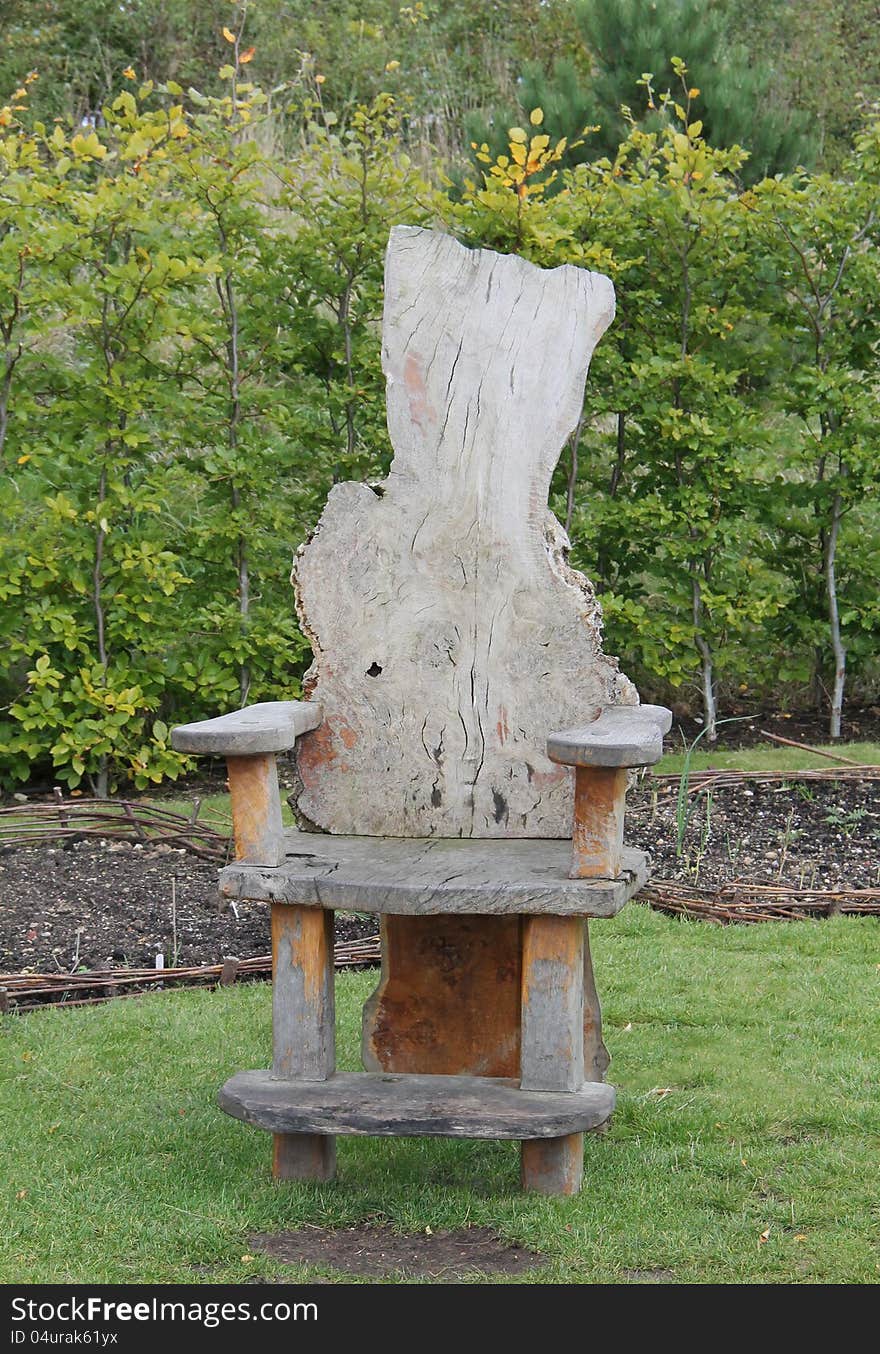 An Unusual Wooden Chair in a Garden Setting. An Unusual Wooden Chair in a Garden Setting.