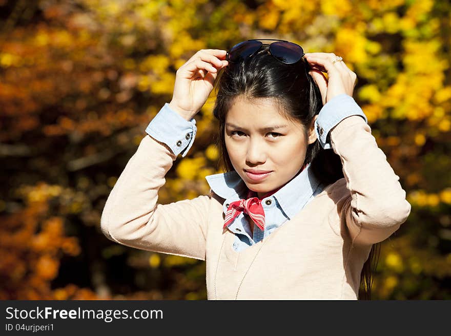 Beautiful young asian woman on a sunny day in fall. Beautiful young asian woman on a sunny day in fall