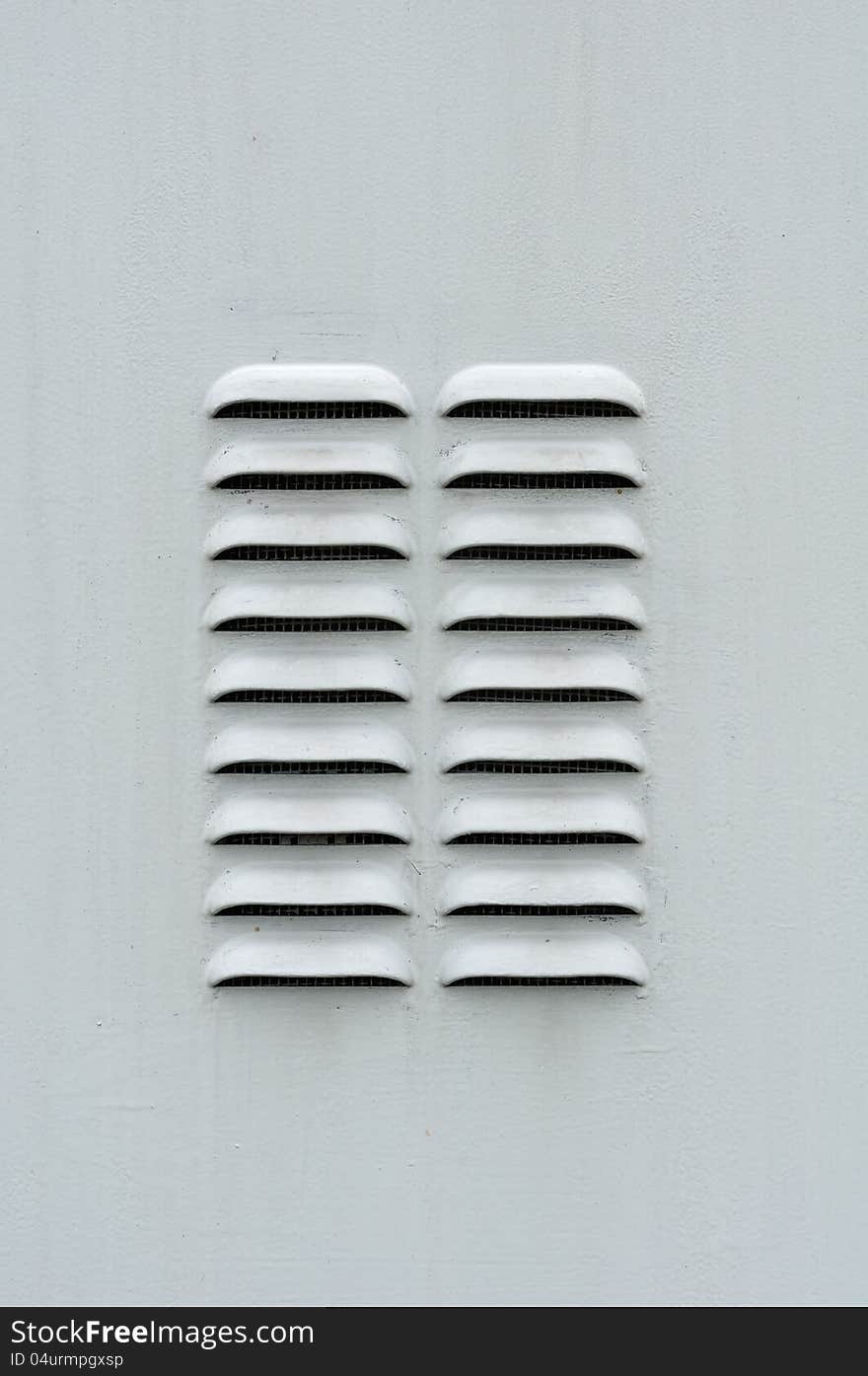 A gray metal ventilation louver with horizontal slats