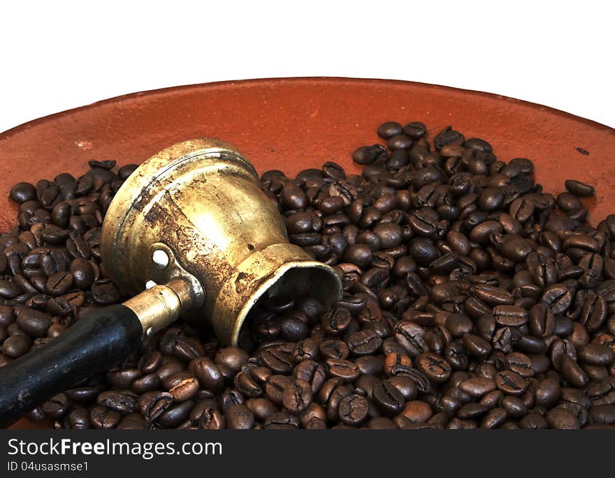 Arab coffee pot and roasted coffee beans on old ceramic plate over white background. Arab coffee pot and roasted coffee beans on old ceramic plate over white background