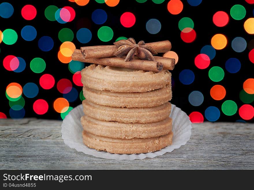 A stack of Christmas cookies, cinnamon and anise on the background of colorful bokeh. A stack of Christmas cookies, cinnamon and anise on the background of colorful bokeh.