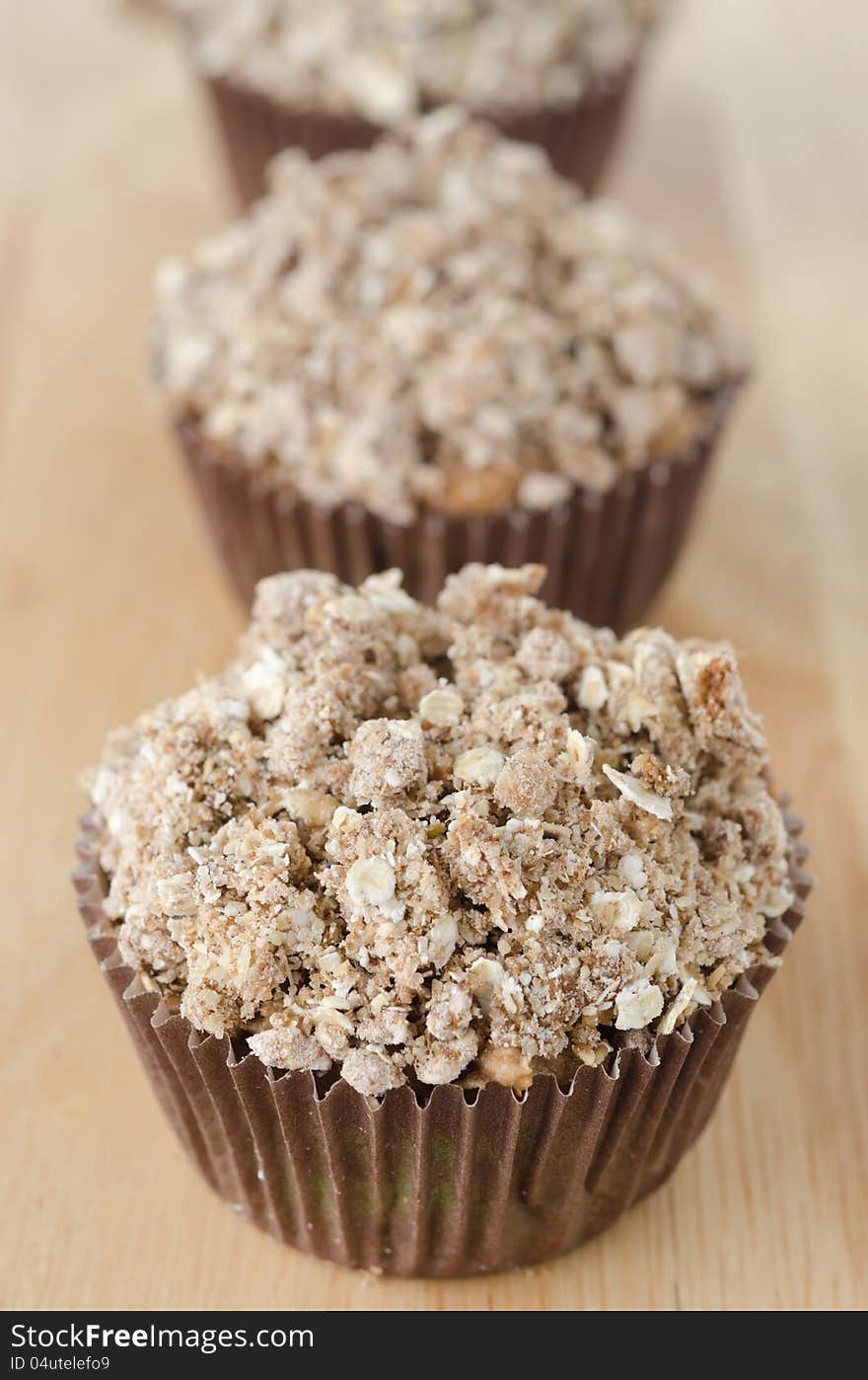 Muffins with apple and crumble topping of oatmeal in paper molds. Muffins with apple and crumble topping of oatmeal in paper molds