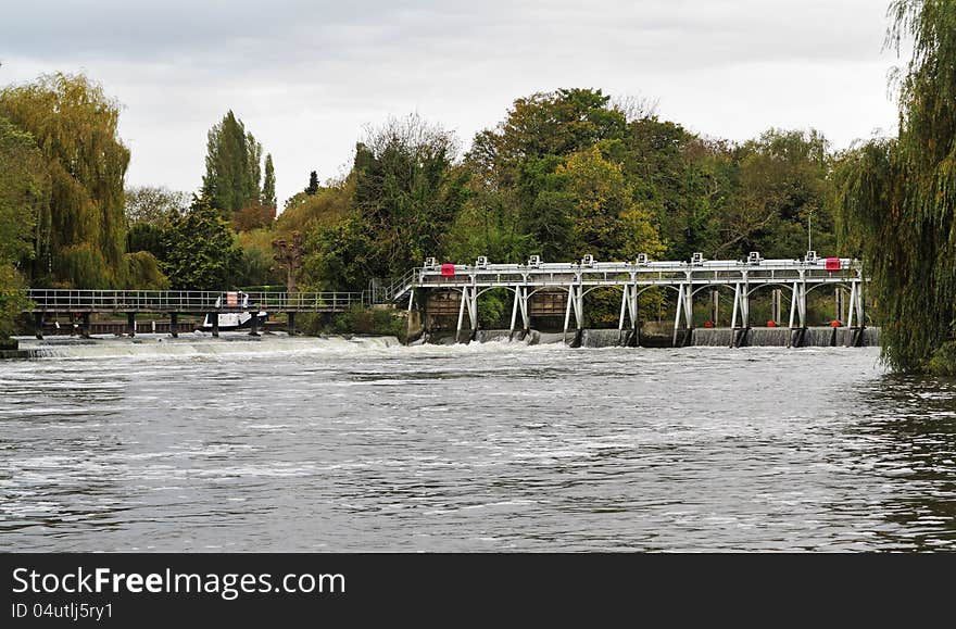 Weir and sluice gate on a swollen River Thames