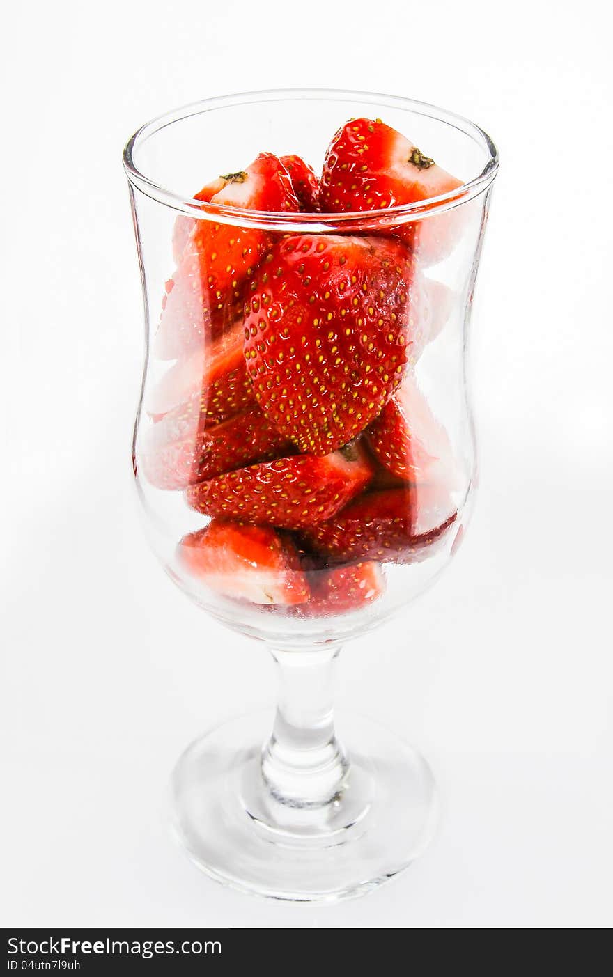 Strawberry pieces in glass side view on white background. It is good for diet, good for health and having a lot of nutrition