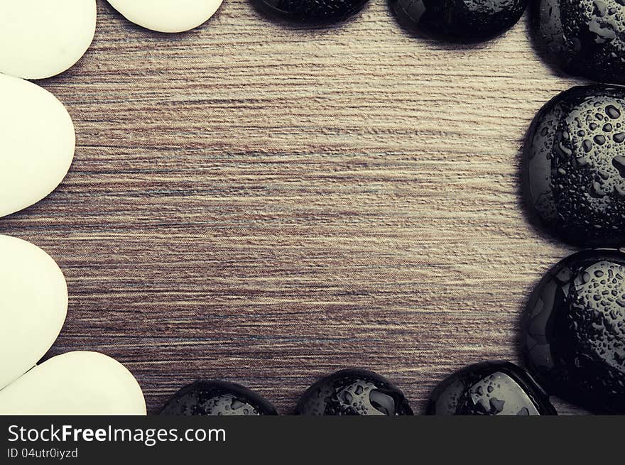 Abstract background spa. stones, pebbles, white and black on a wooden texture. Abstract background spa. stones, pebbles, white and black on a wooden texture