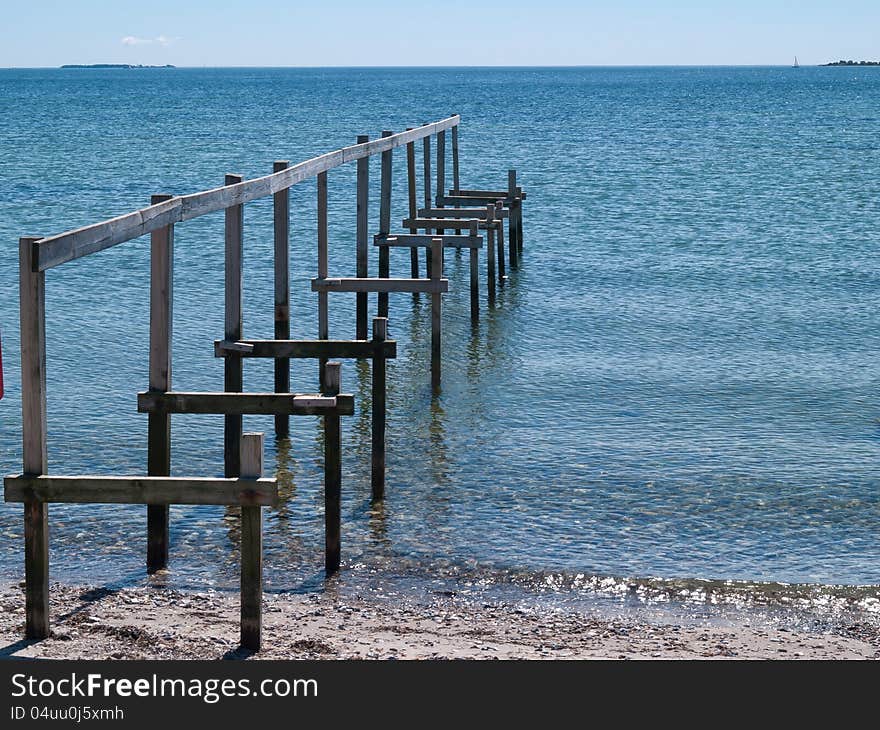 Beautiful seascape of a wooden footbridge with clear blue ocean