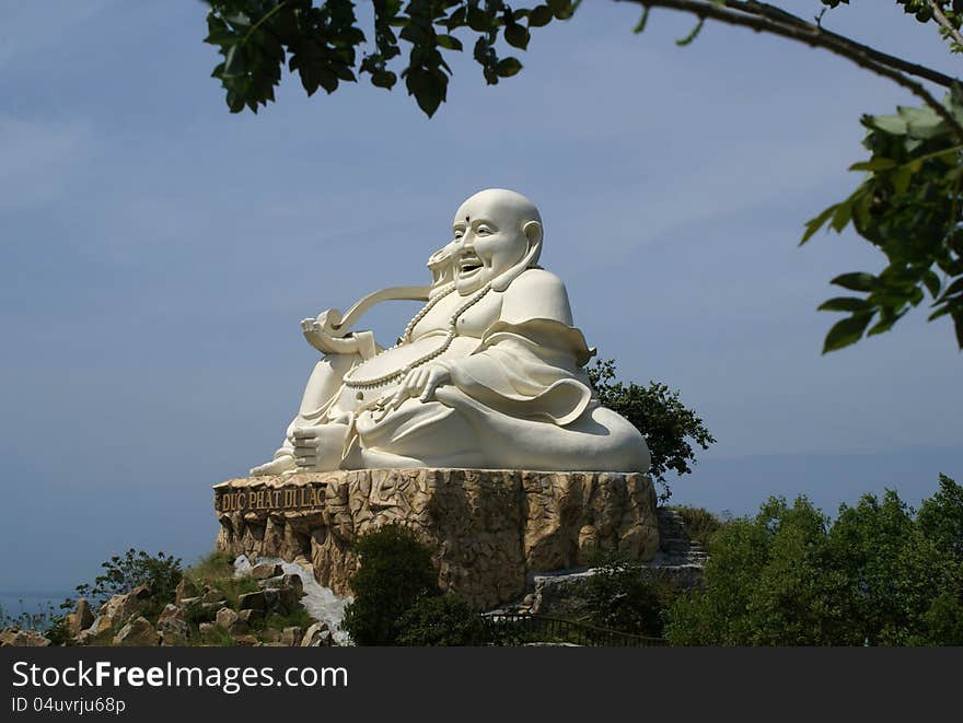 Cheerful statue of the Buddha on a pedestal