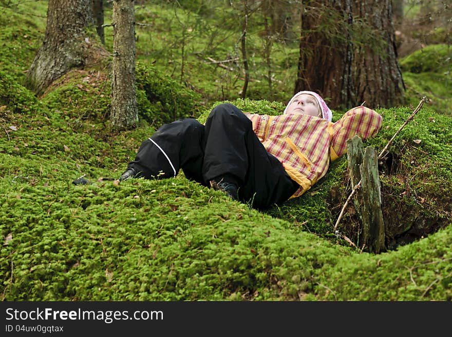 Young girl lying in green moss daydreaming. Young girl lying in green moss daydreaming.