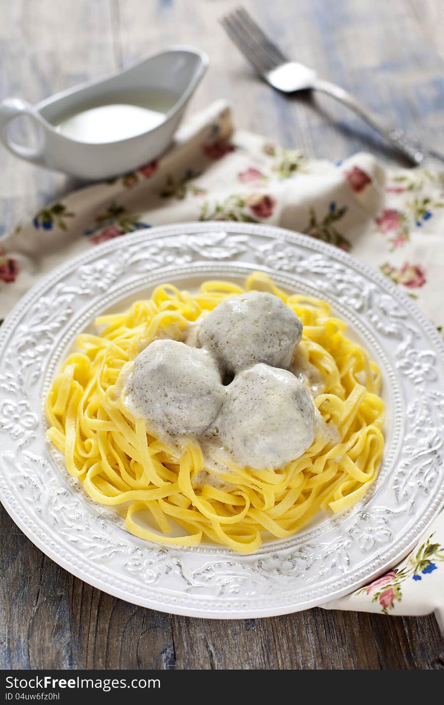 Meatballs with tagliatelli and white sauce in italian style