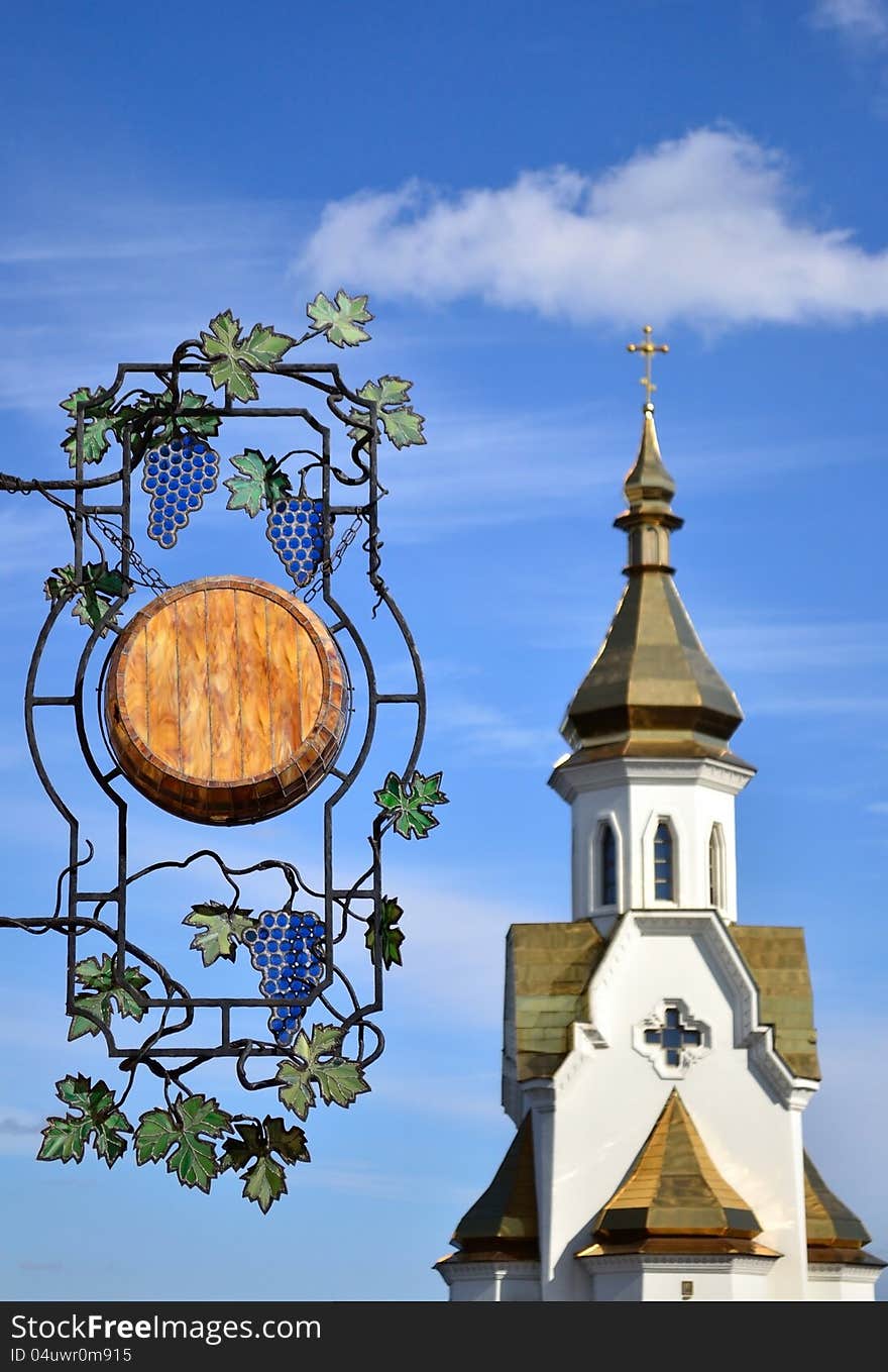 Wooden signboard with forged elements on а church background