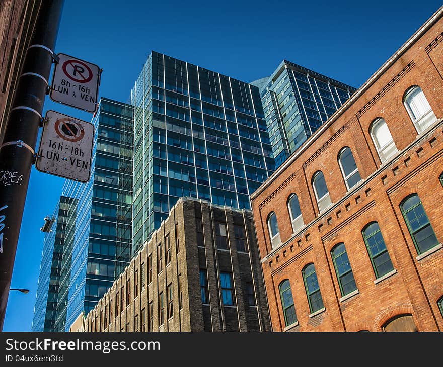 A modern building behind a couple of old buildings. A modern building behind a couple of old buildings