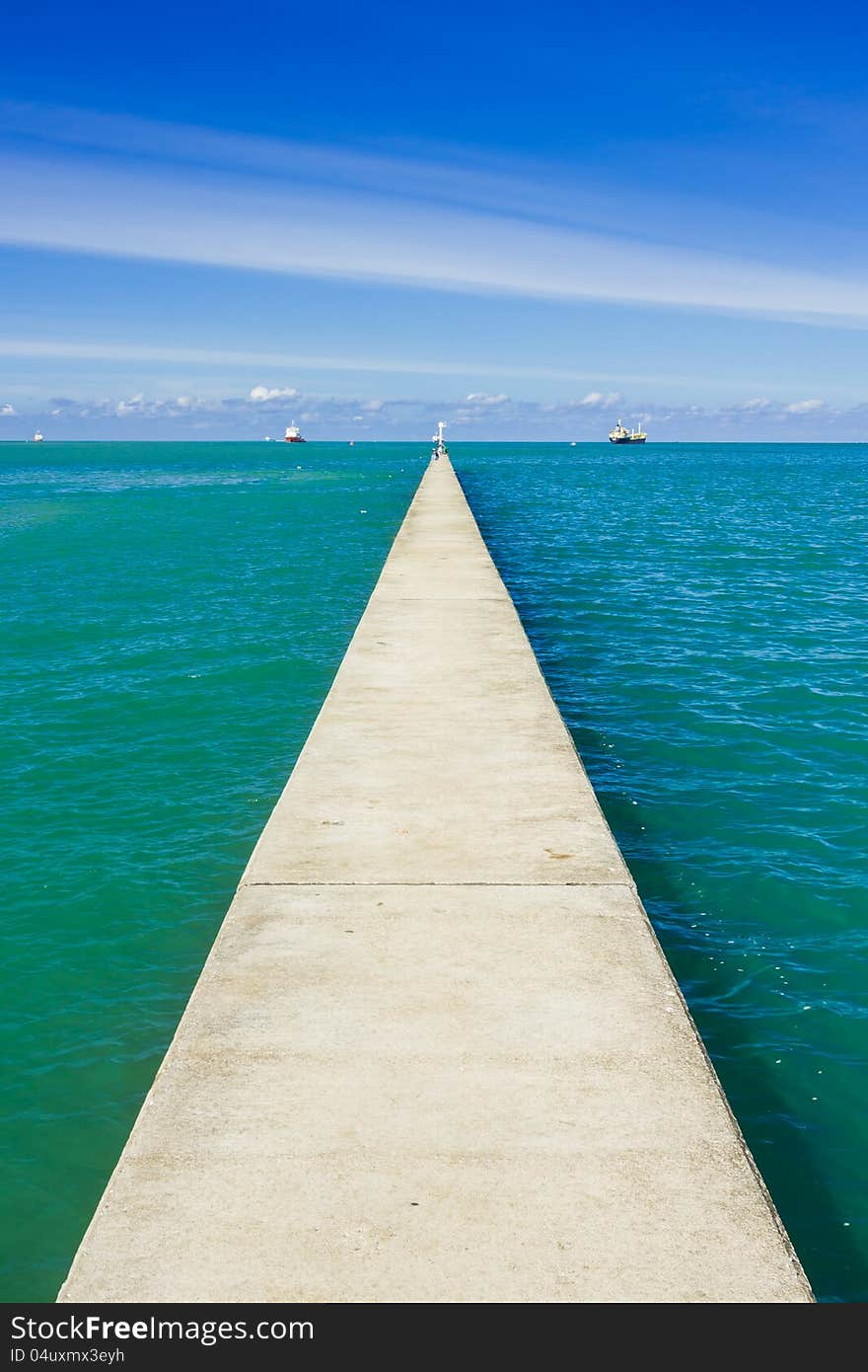 A long and small concrete pier on a sea