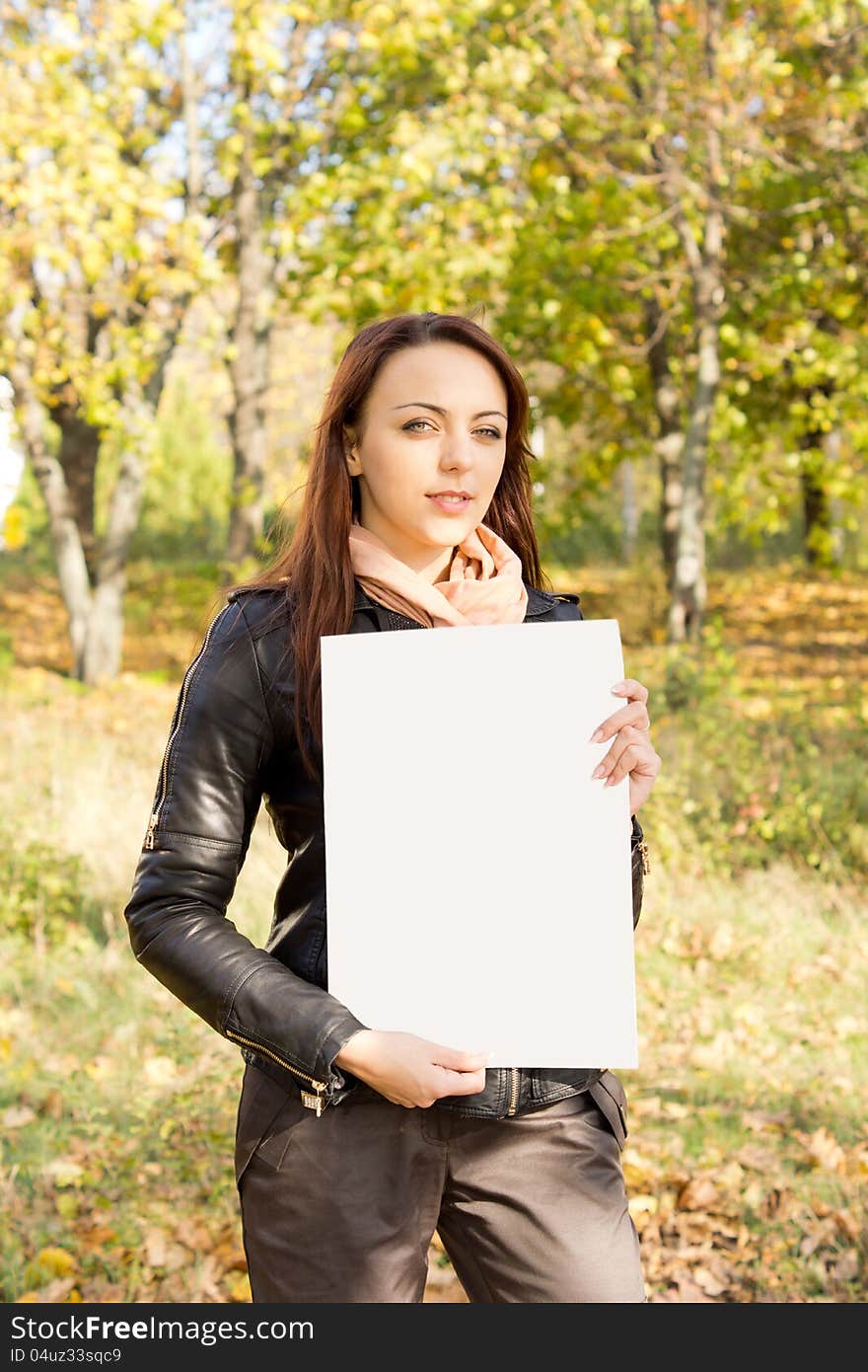 Woman holding a blank sign in woodland