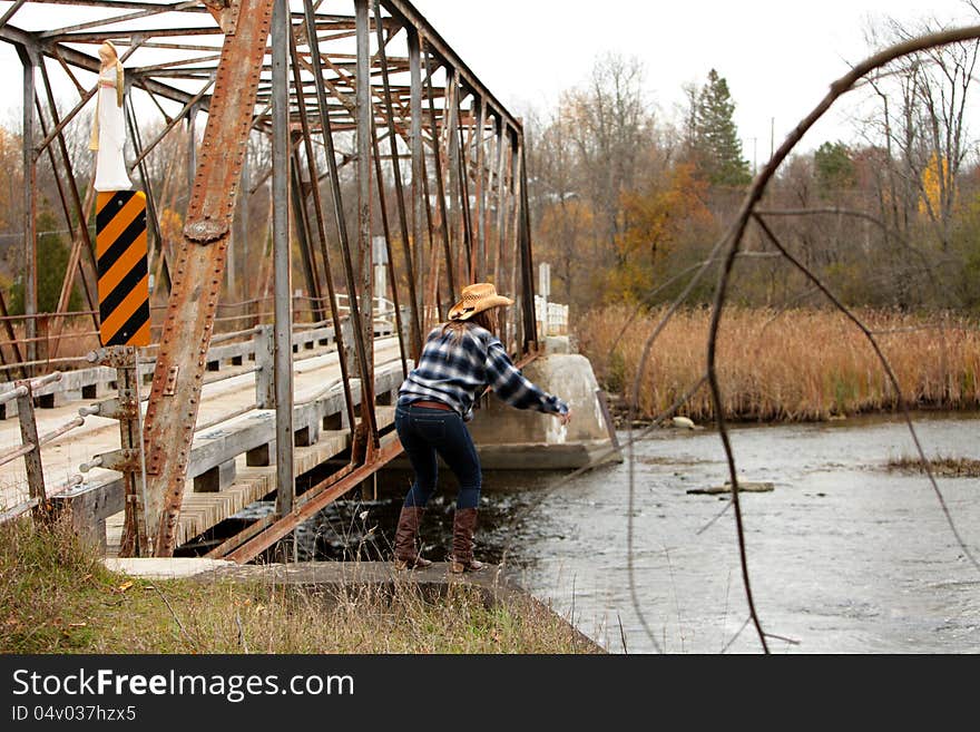 Young girl thinking about jumping off a bridge in Autumn.