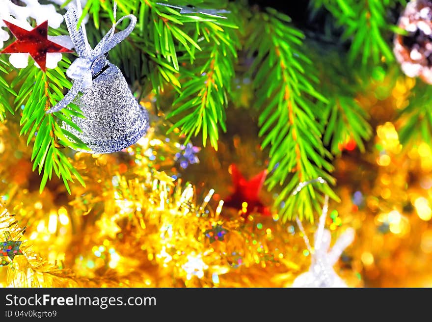 Silver bell hanging on the branch of a Christmas tree. Silver bell hanging on the branch of a Christmas tree