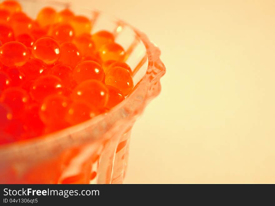 Caviar in the glass on the light brown background. Caviar in the glass on the light brown background