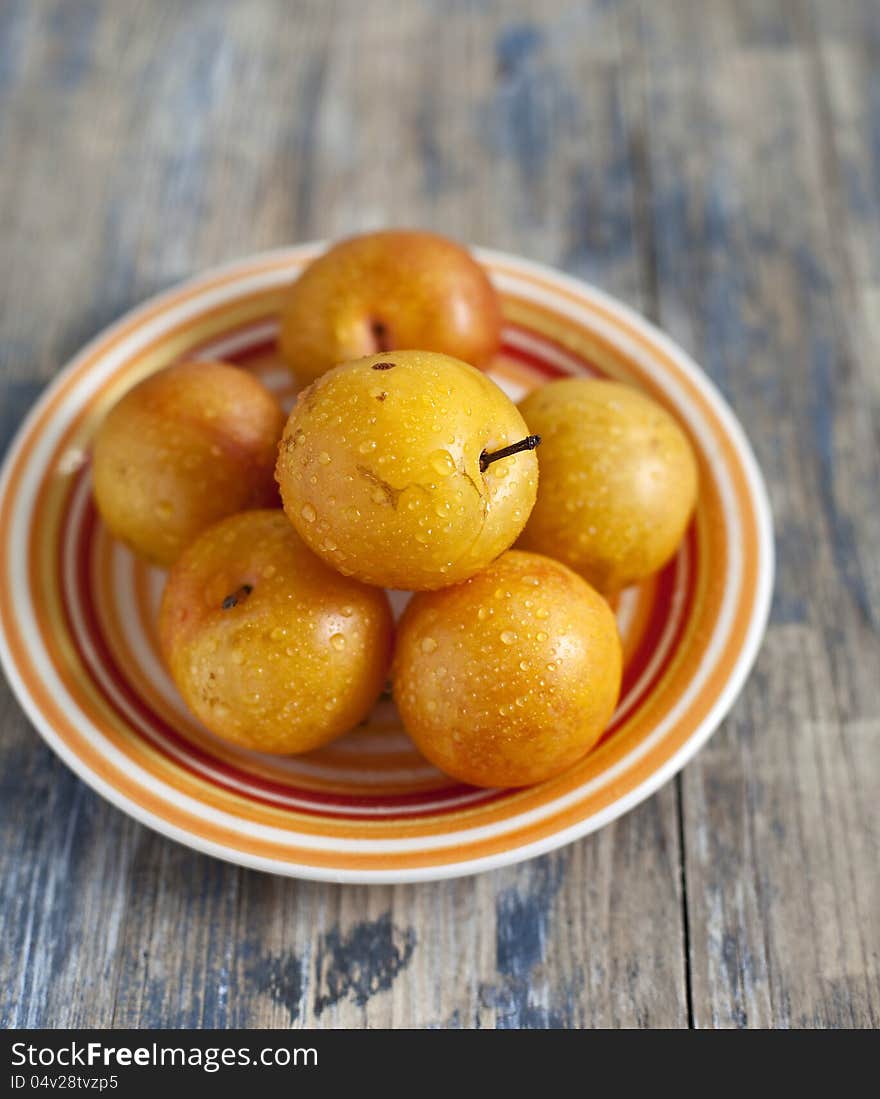 Yellow plums on a colourful plate